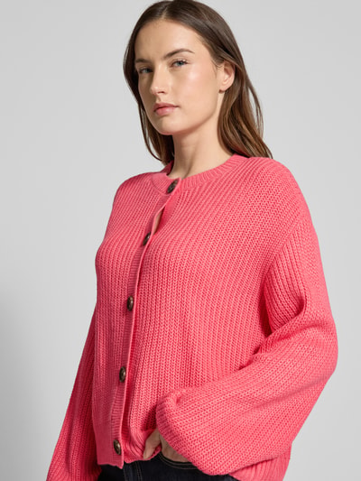 Vrouwenmodel draagt Regular Fit Strickjacke met eenrijige knoopsluiting model 'LEA' van Vero Moda, effen roze, gebreid, close-up bovenlichaam.