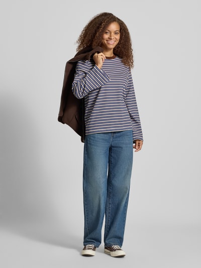 Frauenmodel trägt Oversized Shirt aus reiner Baumwolle Modell 'LISA' von ONLY mit Streifen in Blau, Weiß und Flieder, Damen Oversized Shirt von ONLY, Ganzkörperansicht von vorne.