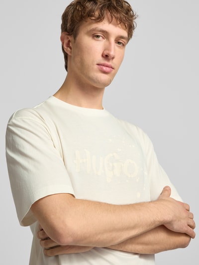 Männermodel trägt Regular Fit T-Shirt aus reiner Baumwolle Modell 'NIEROFIX_U261' von HUGO, Optik: Unifarben, Motiv-Print, Nahaufnahme Oberkörper.