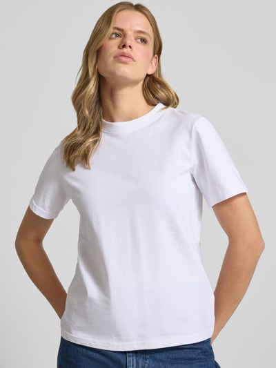 Frauenmodel trägt weißes Regular-Fit Damen T-Shirt aus reiner Baumwolle Modell 'MONJA' von ONLY, glatte Struktur, Nahaufnahme Oberkörper.