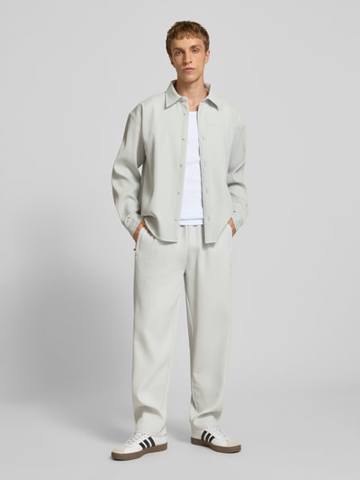 Männermodel trägt Regular Fit Freizeithemd mit Kentkragen und Label-Stitching von Pegador in hellem Farbton, Material-Mix mit Stretch, Ganzkörperansicht von vorne.