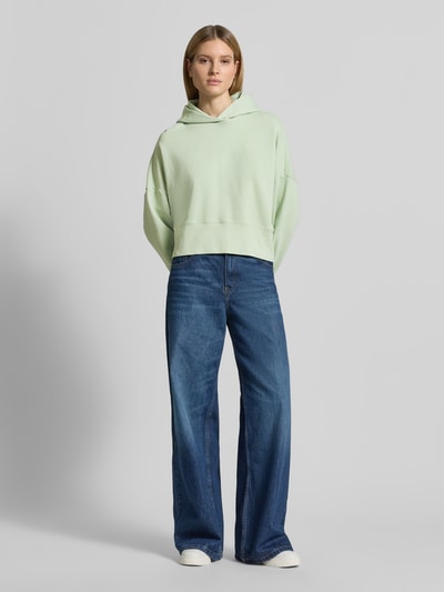 Frauenmodel trägt Relaxed Fit Hoodie aus reiner Baumwolle von Marc O'Polo, Optik: Unifarben, Passform: Relaxed-Fit, Label-Print, Kapuze, Langarm, Rumpfabschluss und Ärmelabschluss gerippt, Materialverarbeitung: Sweat, Ganzkörperansicht von vorne.