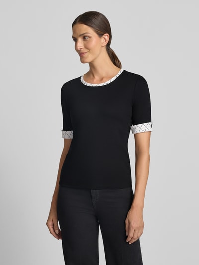 Modelka nosi T-Shirt in Ripp-Optik mit Rundhalsausschnitt von Marc Cain, Mieszanka bawełny i elastanu, krój slim fit, efekt prążkowania, okrągły dekolt, rękawy z zakładką, długość tyłu w rozmiarze 36: 56 cm, widok całej sylwetki z przodu.