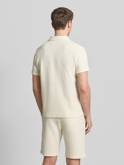 Męski model ma na sobie Regular Fit Poloshirt aus Baumwoll-Mix od MCNEAL, kremowy kolor, wafel-piké, krótki rękaw, perspektywa cała sylwetka z tyłu.