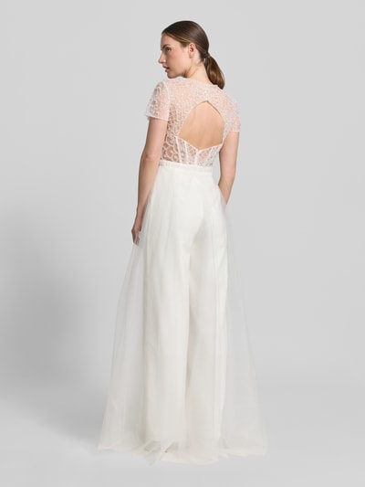 Frauenmodel trägt Jumpsuit mit Perlen und rückseitigem Cut-Out von Unique, semitransparent, Regular-Fit, Ganzkörperansicht Rückansicht, Kontext: Damen Jumpsuit von Unique, Regular Fit, Semitransparent, Rückseitiges Cut Out, Perlen, Hakenverschluss, Rückenlänge bei Größe 36: 40 cm, Brustweite bei Größe 36: 38 cm, Ärmellänge bei Größe 36: 17 cm, Gesamtlänge bei Größe 36: 162 cm, Innenbeinlänge bei Größe 36: 86 cm.
