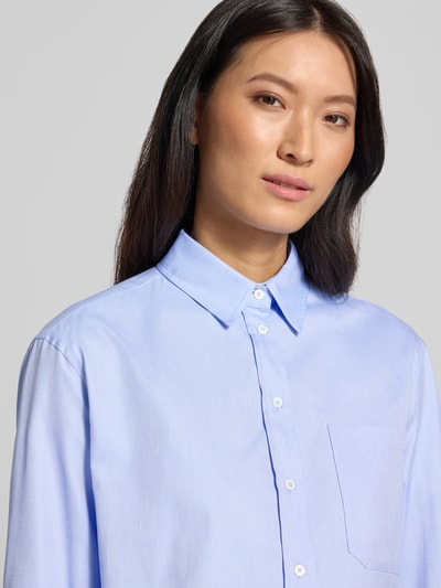 Vrouwenmodel draagt lichtblauwe blouse met lange mouwen van katoen, losse fit, Loose Fit Langarmbluse aus reiner Baumwolle Modell 'NUORO' van Weekend Max Mara, Nahaufnahme bovenlichaam.