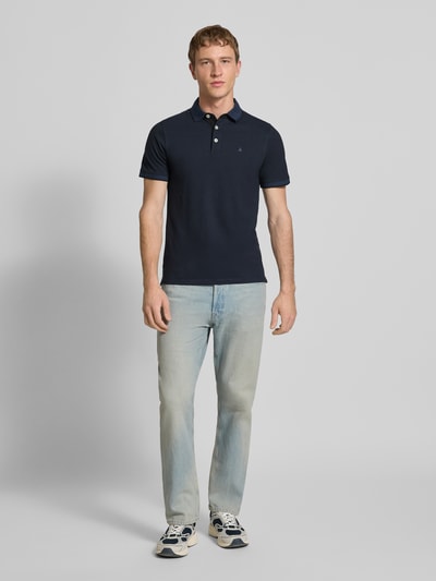 Männermodel trägt Slim Fit Poloshirt mit Viskose-Anteil Modell 'Paulos' von JACK & JONES, Baumwoll-Mix, Polokragen, Logo-Stitching, Herren, Ganzkörperansicht von vorne.
