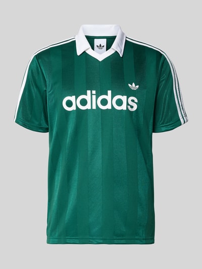 Produktfoto, Trikot mit Umlegekragen und Label-Print von adidas Originals in Dunkelgrün mit weißen Details, Regular Fit, V-Ausschnitt, dezente Streifenoptik
