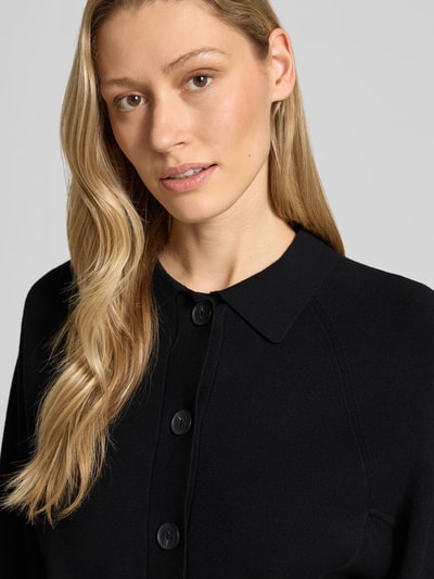 Frauenmodel trägt Cardigan aus Viskose-Mix mit Umlegekragen Modell 'Turea' von Someday, Knopfleiste, Schwarz, Nahaufnahme Oberkörper.