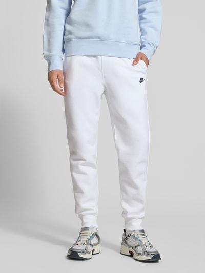 Männermodel trägt Sweatpants mit Label-Stitching und Gesäßtasche von Nike aus Baumwoll-Mix in Regular-Fit, Ganzkörperansicht von vorne.