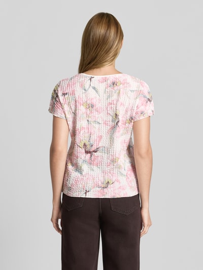 Modelka kobieca nosi T-Shirt im Allover-Look mit Strukturmuster od Betty Barclay, materiał z domieszką stretchu, krój regular fit, kolorowy wzór kwiatowy, okrągły dekolt, długość tyłu w rozmiarze 36: 54 cm, tekstura prążkowana, widok całej sylwetki od tyłu
