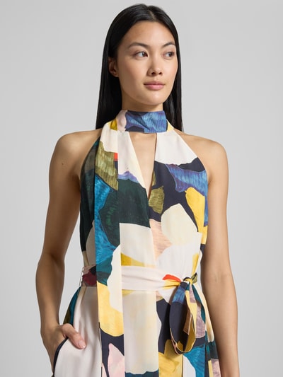 Frauenmodel trägt Regular Fit Jumpsuit aus reiner Viskose Modell 'Camea' von Ted Baker mit buntem Print, Nahaufnahme Oberkörper. Damen Jumpsuit, ärmellos, Stehkragen, Schlüsselausschnitt, taillierte Passform, weiche Textur, Produktdetails laut Kontext sichtbar.