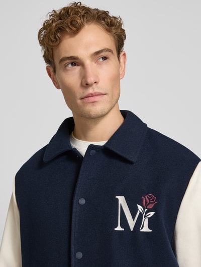 Männermodel trägt Regular Fit jack met motiefstitching van MCNEAL in marineblauw en crème met platte kraag en knoopsluiting, Nahaufnahme Oberkörper, Ruglengte bij maat M: 68 cm, Mouwlengte bij maat M: 68 cm.