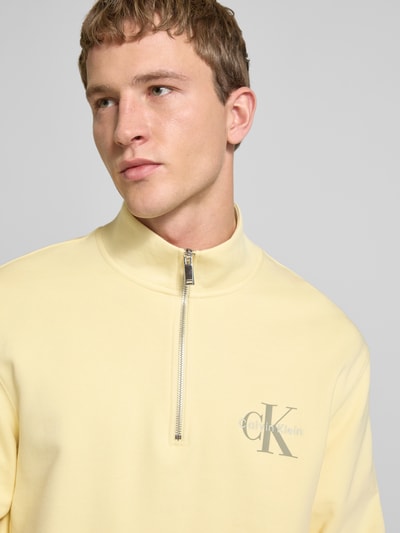 Männermodel trägt Sweatshirt mit Stehkragen und Reißverschluss von Calvin Klein Jeans, Regular-Fit, reine Baumwolle, Logo, Nahaufnahme Oberkörper.