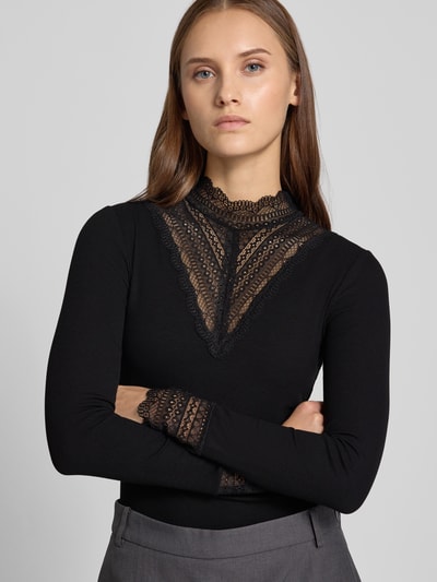 Frauenmodel trägt schwarzes Slim Fit Langarmshirt aus Viskose-Mix Modell 'TILDE' von ONLY, Damen Langarmshirt, Nahaufnahme Oberkörper.