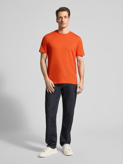 Męski model nosi Regular Fit T-Shirt aus reiner Baumwolle von Tommy Hilfiger, unikat kolor, logo, krój regular fit, krótki rękaw, jersey, bawełna, ganzkörperansicht von vorne.