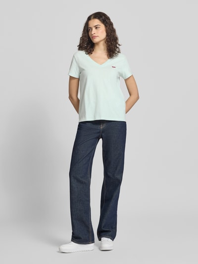 Modelka nosi Regular Fit T-Shirt aus reiner Baumwolle Modell 'LSE_PERFECT TEE' od Levi's®, jednolita, krój regular fit, krótki rękaw, V-dekolt, białe, naszywka z logo, czysta bawełna, pełny widok z przodu.