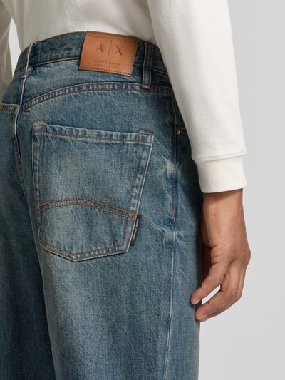 Männermodel trägt Jeans im 5-Pocket-Design von Armani Exchange in Blau mit Used-Look, reine Baumwolle, Nahaufnahme Rückansicht.
