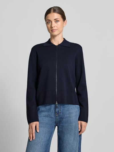 Frauenmodel trägt Strickjacke aus reiner Schurwolle Modell 'SNACK' von MM by Max Mara in Dunkelblau, mit Umlegekragen und Zweiwege-Reißverschluss, taillierte Passform, Ganzkörperansicht von vorne.