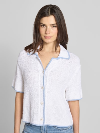 Frauenmodel trägt Strickjacke mit Viskose-Anteil von Marc Cain, weiß mit blauen Kanten, Baumwoll-Mix, Knopfleiste, Nahaufnahme Oberkörper.