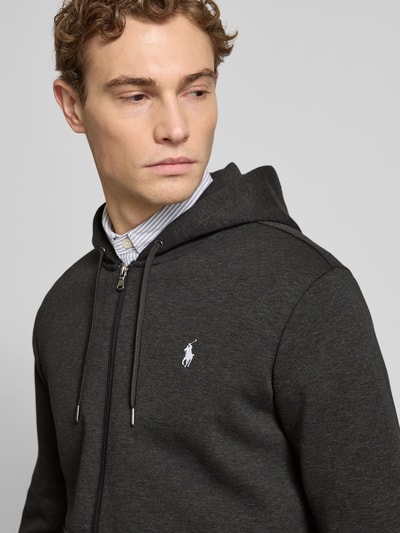 Männermodel trägt Regular Fit Sweatjacke aus Baumwoll-Mix von Polo Ralph Lauren in Dunkelgrau mit Kapuze, Reißverschluss und Logo-Detail, Nahaufnahme Oberkörper.