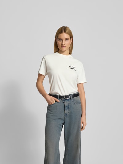 Frauenmodel trägt T-Shirt mit Label-Print von Anine Bing in Weiß aus Reine Baumwolle, Lockerer-Schnitt, Gerippter Rundhalsausschnitt, Ganzkörperansicht von vorne. Rückenlänge bei Größe S: 70 cm.