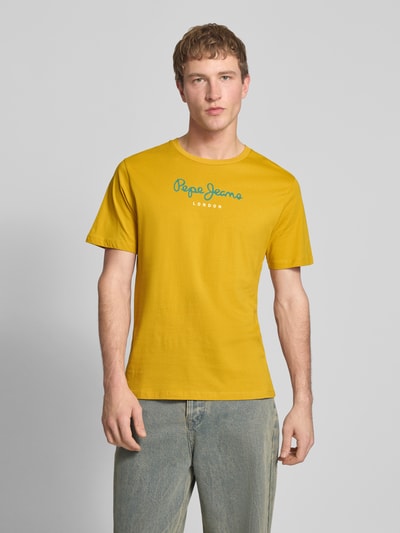Mężczyzna nosi Regular Fit T-Shirt aus reiner Baumwolle Modell 'EGGO' von Pepe Jeans, kolor jednolity, nadruk z logo, materiał jersey, widok całej sylwetki z przodu.
