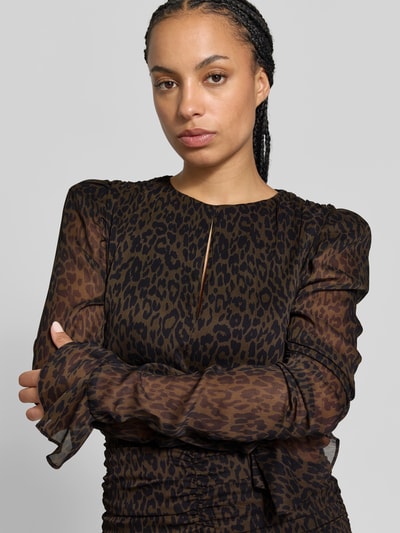 Frauenmodel trägt Minikleid mit Allover-Animal-Print von ROTATE, braun-schwarzer Farbverlauf, schmale Passform, Schlüssellochausschnitt, langärmlig, raffinierte Raffung, transparente Textur, Nahaufnahme Oberkörper.