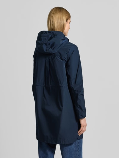 Frauenmodel trägt Mantel mit Eingrifftaschen von Fuchs Schmitt in Dunkelblau, Gerader-Schnitt, Kapuze, Rückenlänge 90 cm, Ganzkörperansicht Rückansicht.