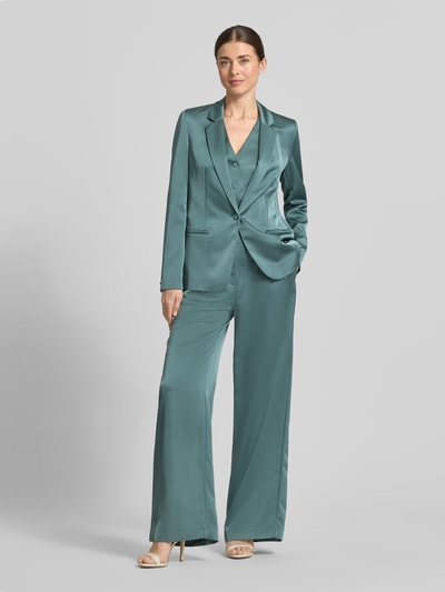 Modelka kobieca nosi Hose mit weitem Bein und Falten von Jake*s Cocktail, satyn, szerokie nogawki, zaszewki, kieszeń tylna, szerokość w rozmiarze 36: 34 cm, długość nogawki wewnętrznej w rozmiarze 36: 82 cm, cała sylwetka z przodu.