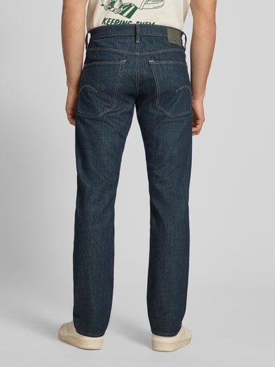 Männermodel trägt Slim Tapered Fit Jeans Modell 'Streem' von G-Star Raw, dunkelblauer Denim, klassische Nähte, Ganzkörperansicht Rückansicht.