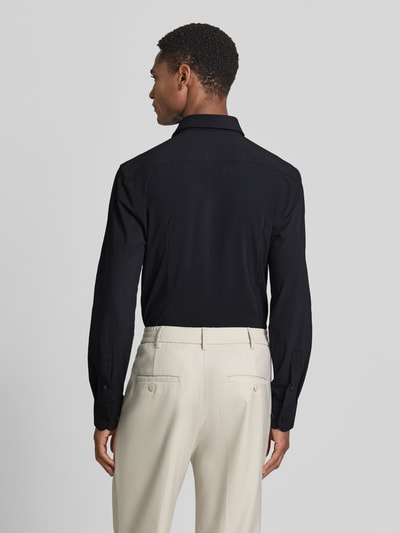 Männermodel trägt Slim Fit Businesshemd mit Kentkragen Modell 'P-HANK-S' von BOSS, unifarben, Ganzkörperansicht Rückansicht.