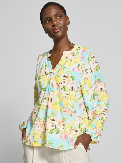 Frauenmodel trägt Regular Fit Bluse aus Viskose im Allover-Look von Emily Van den Bergh, bunte Muster, V-Ausschnitt, Nahaufnahme Oberkörper. Rückenlänge bei Größe 36: 63 cm, Ärmellänge bei Größe 36: 60 cm, Reine Viskose.