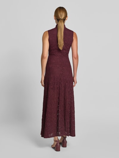 Frauenmodel trägt Maxikleid mit Allover-Spitzenbesatz von ROTATE in Dunkelrot, Elastischer-Material-Mix mit Baumwoll-Anteil, Slim-Fit, Stehkragen, Ärmelloses-Design, zarte Spitzenstruktur, Ganzkörperansicht Rückansicht. Gesamtlänge 144 cm, Brustweite 44 cm bei Größe 36.