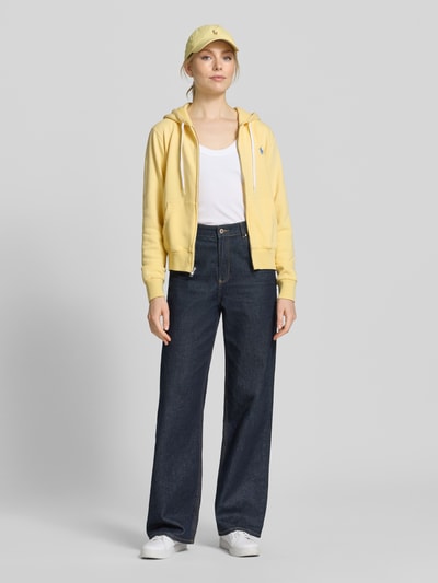 Kobiece model prezentuje Regular Fit Sweatjacke aus Baumwoll-Mix od Polo Ralph Lauren, żółty kolor, dżinsy, pełny przód