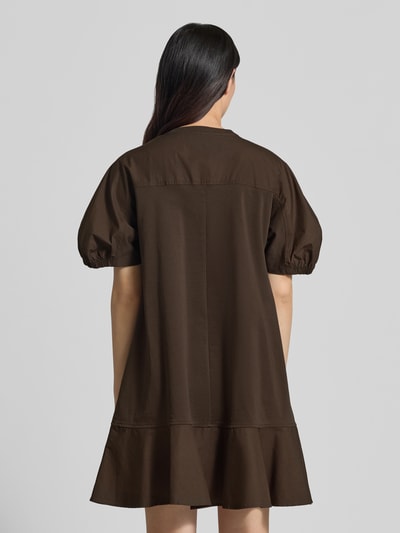 Kobiece model prezentuje sukienkę tunikową knielanges Tunikakleid mit Puffärmeln Modell 'ONORE' von MM by Max Mara, mieszanka bawełny z dodatkiem streczu, linia a, długość do kolan, okrągły dekolt, bufiaste rękawy, długość tyłu w rozmiarze s: 90 cm, szerokość w rozmiarze s: 50 cm, długość rękawów w rozmiarze s: 30 cm, brązowy, matowa tekstura, widok całej sylwetki z tyłu.