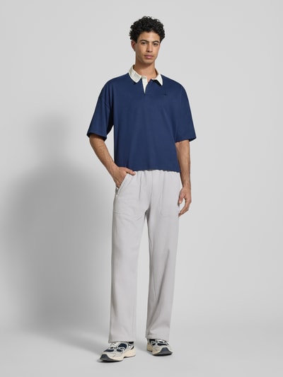Mannelijk model draagt Straight fit Sweatpants met structuurpatroon Model 'Essentials' van adidas Originals in katoenmix met steekzakken, elastische band, binnenbeenlengte maat M 77 cm, lichtgrijs en blauw, ganze lichaamsaanzicht van voren.