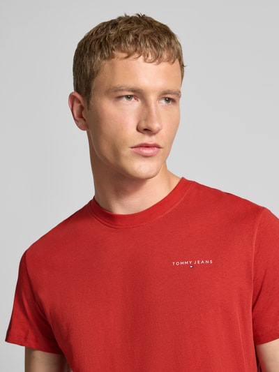 Männermodel trägt Slim Fit T-Shirt aus reiner Baumwolle von Tommy Jeans, Optik: Unifarben, Label-Print, Rundhals, Kurzarm, Nahaufnahme Oberkörper.