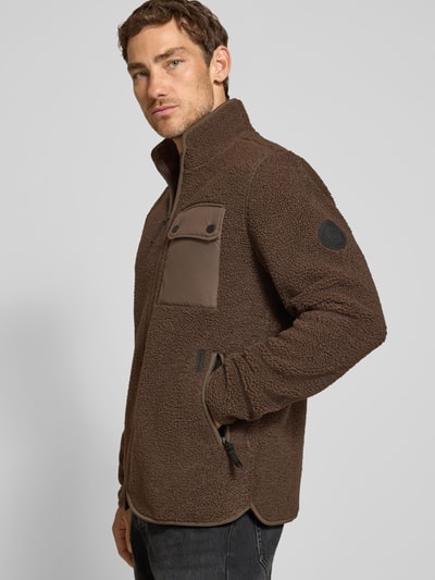 Männermodel trägt braune Regular Fit Jacke mit Stehkragen Modell 'Peter' von Didriksons, Strukturmuster, Ganzkörperansicht von vorne.
