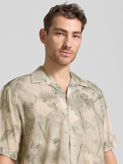 Männermodel trägt Relaxed Fit Freizeithemd aus Bio-Baumwoll-Modal-Mix Modell 'RELAXAIR' von SELECTED HOMME, Optik: Unifarben, Hemdkragen: Reverskragen, Knopfleiste: durchgehend, Ärmelform: Kurzarm, Nahaufnahme Oberkörper.