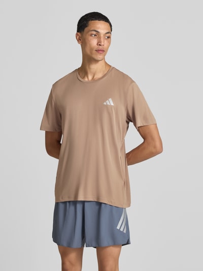 Mężczyzna nosi Regular Fit Sport-T-Shirt mit Logo-Print Modell 'Run Ess Tee M' von adidas Training w jasnobrązowym kolorze, krótki rękaw, gładka faktura, Ganzkörperansicht z przodu.