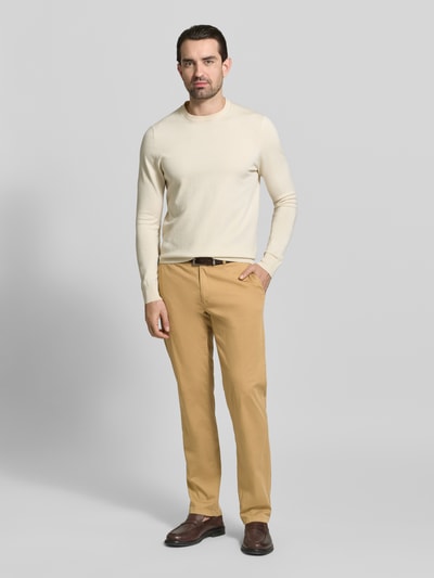 Männermodel trägt Hose mit Gesäßtaschen Modell 'Evans' von BRAX aus Baumwoll-Mix mit Stretch-Anteil, Slim-Fit, Ganzkörperansicht von vorne.