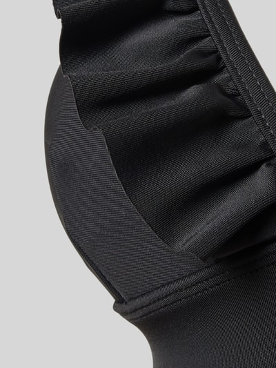 Frauenmodel trägt Bikini-Set mit Rüschen Modell 'BOBBY' von Shiwi aus schwarzem Material-Mix mit Stretch-Anteil, körpernahe Passform, Detailaufnahme.