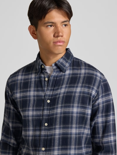Männermodel trägt Regular Fit Freizeithemd mit Kentkragen Modell 'FIELD' von JACK & JONES, blau kariert, Nahaufnahme Oberkörper. Reine Baumwolle.