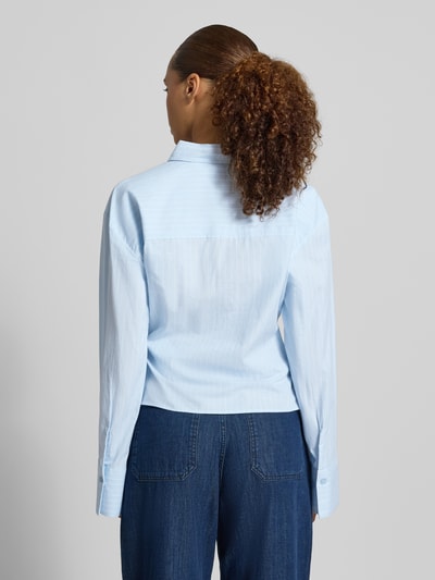 Frauenmodel trägt Regular Fit Hemdbluse aus reiner Baumwolle Modell 'Bella' von My Essential Wardrobe in Hellblau, Rückenansicht. Reine Baumwolle, Zierbesatz, Hemdblusenkragen, langärmeliges Design, Rückenlänge 55 cm, Ärmellänge 59 cm bei Größe 36.