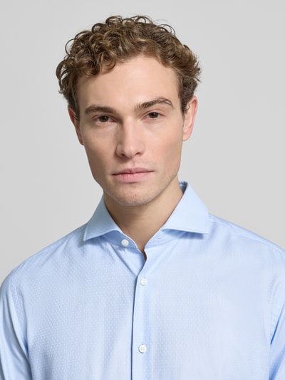 Männermodel trägt Regular Fit Businesshemd aus reiner Baumwolle Modell 'JOE' von BOSS, Strukturierte Optik, Nahaufnahme Oberkörper.