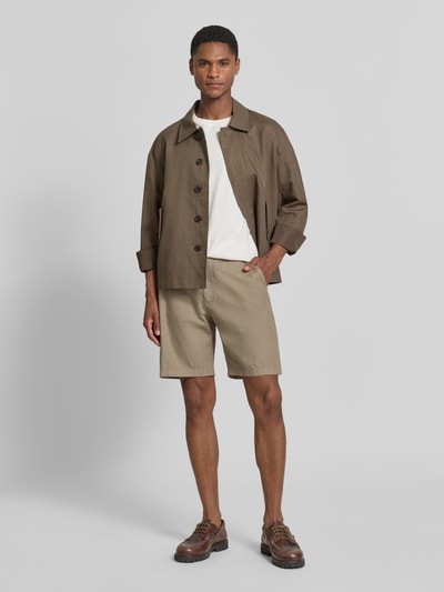 Männermodel trägt Shorts mit Gesäßtaschen Modell 'YASAN' von Drykorn, Leinen-Baumwoll-Mix, Regular-Fit, Ganzkörperansicht von vorne.