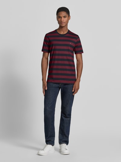Männermodel trägt Regular Fit T-Shirt mit Logo-Stitching von Christian Berg Men, gestreift in Rot und Dunkelblau, Reine Baumwolle, Rundhalsausschnitt, Rückenlänge bei Größe M 70 cm, Ganzkörperansicht von vorne.