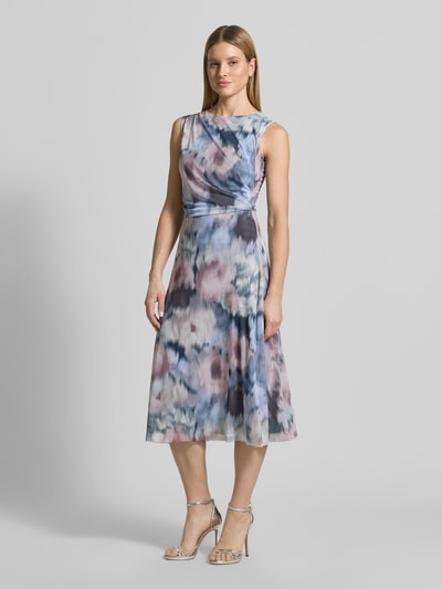 Vrouwenmodel draagt Regular Fit midi-jurk met plooien van Swing, elastische materiaalmix, mesh, mouwloos design, bloemen all-over print, gevoerde onderrok, getailleerde pasvorm, ruglengte maat 36: 117 cm, borstwijdte maat 36: 37 cm, voorkant geheel zichtbaar, Ganzkörperansicht von vorne.