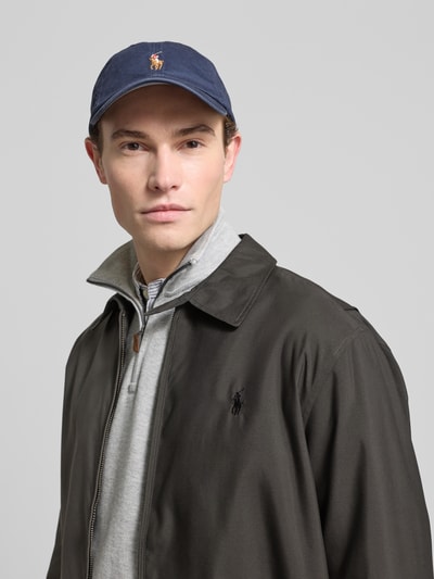 Męski model nosi Kurtkę z wyhaftowanym logo Jacke mit Label-Stitching od Polo Ralph Lauren, krój regular fit, kołnierzyk typu kent, zamek błyskawiczny, wpuszczane kieszenie, długość tyłu 68 cm, szerokość ramion 49 cm, szerokość klatki piersiowej 62 cm, długość rękawów 64 cm, stonowane kolory, gładka tekstura, całkowite ujęcie górnej części ciała z przodu.